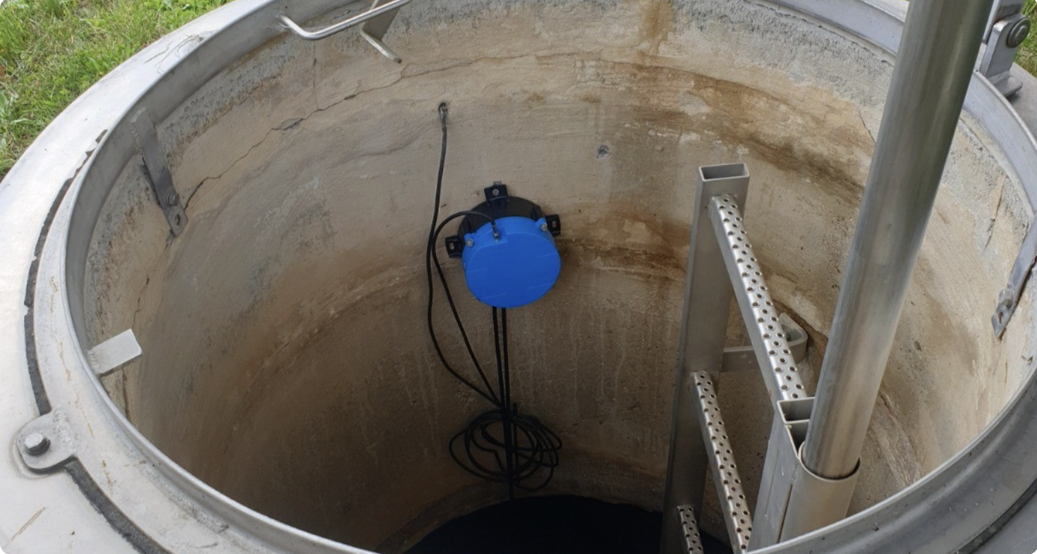AQ IoT Datenlogger installiert in einem Straßenschacht mit grüner LED-Anzeige